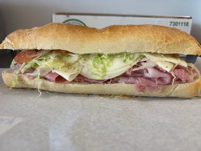 Cold sandwich with ham, provolone, lettuce, tomato, and onion